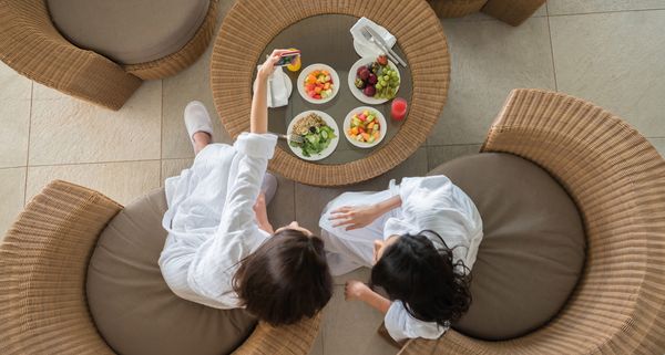 Damen vor einem runden Tisch mit gesunden Speisen